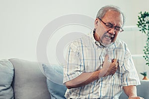 An agonizing senior man suffering from chest pain or heart attack.