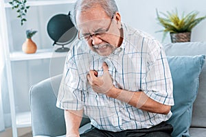 An agonizing senior man suffering from chest pain or heart attack.