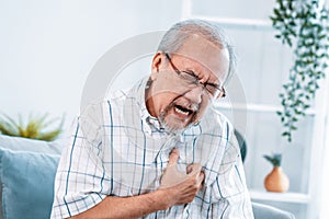 An agonizing senior man suffering from chest pain or heart attack.