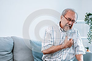 An agonizing senior man suffering from chest pain or heart attack.