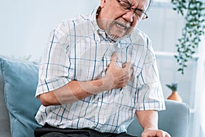 An agonizing senior man suffering from chest pain or heart attack.