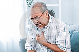 An agonizing senior man suffering from chest pain or heart attack. photo