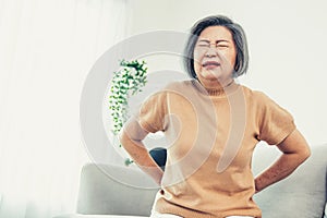 An agonizing senior woman experiencing back pain.