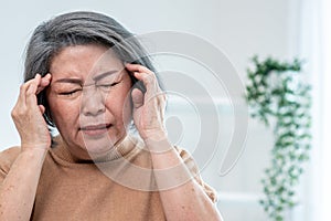 An agonizing senior woman with a headache in her contented environment.