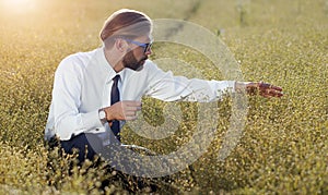 Agrarian engineer squatting ripe field