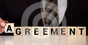 AGREEMENT word on wooden cubes on gray background