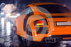 Agressive and brutal orange sport car on rained road picture useful for background