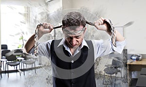 Agressive businessman with a tie on his head