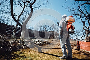 agricultural details - farmer working, spraying pesticides in fruit orchard