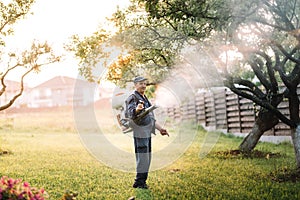 agricultural details - farmer working, spraying pesticides in fruit orchard