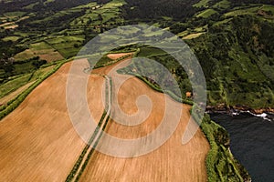 Agricultural fields above wavy ocean on sunny day