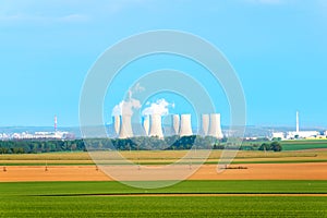 Agricultural fields with cooling towers of nuclear power plant in background