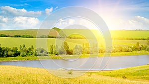 Agricultural fields, lake and bright sunrise. Wide photo