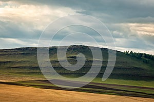 Agricultural fields, meadows and grass hills in steppe.