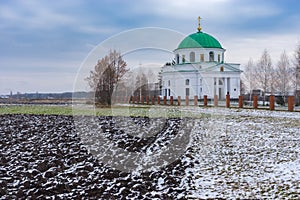 Agricultural fields near an ancient church of St. Nicholas 1797 in the urban settlement Dikanka, Ukraine