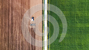 Agricultural landscape from air. Farm machine on the field. Harvesting on the field. Road through the field. Top view from flying