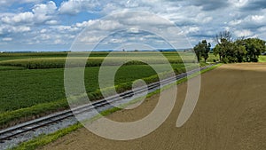 Agricultural Landscape Featuring Parallel Tracks And A Dirt Road Beside Cultivated Fields