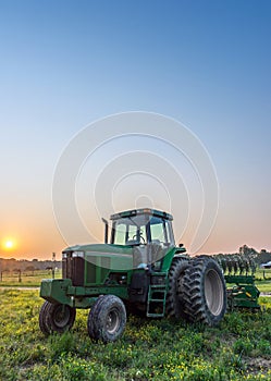 Agricultural landscape of a tractor in a field on a Maryland Farm at sunset