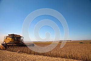 Agricultural machine harvesting soybean field.