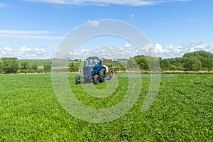 Agricultural machinery, Tractor and farmer in agricultural fields of wheat and rapeseed