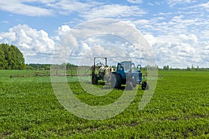 Agricultural machinery, Tractor and farmer in agricultural fields of wheat and rapeseed