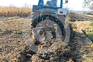 Agricultural machinery works of tractor working at a field