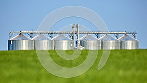 Agricultural Silos - Building Exterior, Storage and drying of grains, wheat, corn, soy, sunflower against the blue sky with wheat