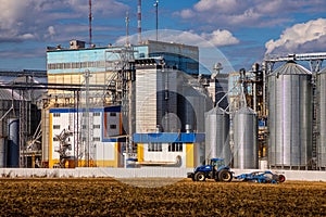 Agricultural Silos. Storage and drying of grains, wheat, corn, soy, sunflower against the blue sky with white clouds.Storage of