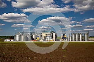 Agricultural Silos. Storage and drying of grains, wheat, corn, soy, sunflower against the blue sky with white clouds.Storage of