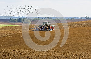 Agricultural tractor cultivating on farmland photo
