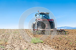 Agricultural tractor in the foreground with blue sky background
