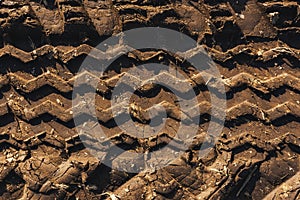 Agricultural tractor tire tracks in dirt road ground