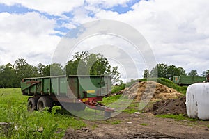 Agricultural trailers parked on the side of the farm in country side village. Trailers. Farm trailer, tractor truck
