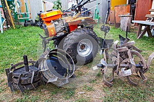 Agricultural walk-behind tractor with a set of attachments, hiller, milling cutters and lugs. Two-wheel tractor