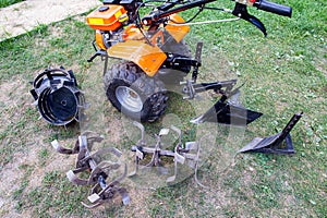 Agricultural walk-behind tractor with a set of attachments, hiller, milling cutters and lugs. Two-wheel tractor