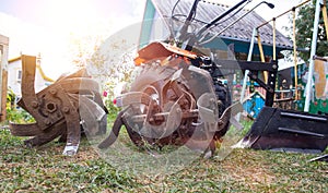 Agricultural walk-behind tractor with a set of attachments, hiller, milling cutters and lugs. Two-wheel tractor, industry