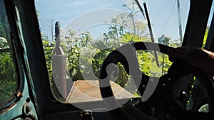 Agricultural worker driving tractor, destroying dangerous cow parsnip plant