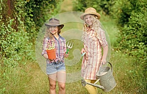Agriculture concept. Girls in hats planting plants. Sisters helping at farm. Family farm. Kids having fun at farm. Eco