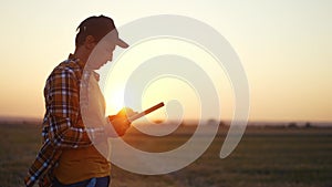 agriculture. farmer with tablet a works on agricultural land. business industry agriculture concept. farmer silhouette