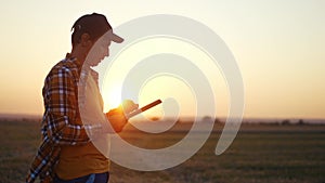 Agriculture. farmer with tablet a works on agricultural land. Business industry agriculture concept. Farmer silhouette