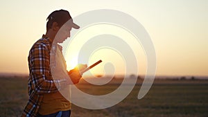 agriculture. farmer with tablet a works on agricultural land. business industry agriculture concept. farmer silhouette