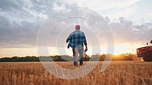 Agriculture. Farmer walk works in a field next to a tractor that plows the land. Business agriculture concept. Farmer