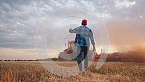 Agriculture. Farmer walk works in a field next to a tractor that plows the land. Business agriculture concept. Farmer