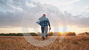 Agriculture. Farmer walk works in a field next to a tractor that plows the land. Business agriculture concept. Farmer