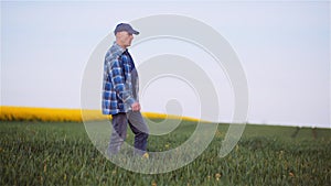 Agriculture Farmer Walking on Agricultural Young Wheat Field.