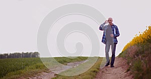 Agriculture Farmer Walking on Agricultural Young Wheat Field.