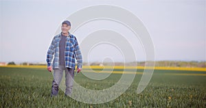 Agriculture Farmer Walking on Agricultural Young Wheat Field Examining Crops.