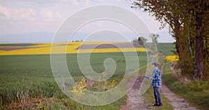 Agriculture Farmer Walking on Agricultural Young Wheat Field Examining Crops.