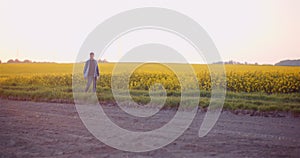 Agriculture - Farmer Walking on Field Examining Crops at Farm at Dusk.