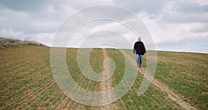 Agriculture - female farmer walking on agricultural field